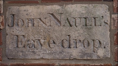 Eavesdrop Stone, displayed on wall at museum